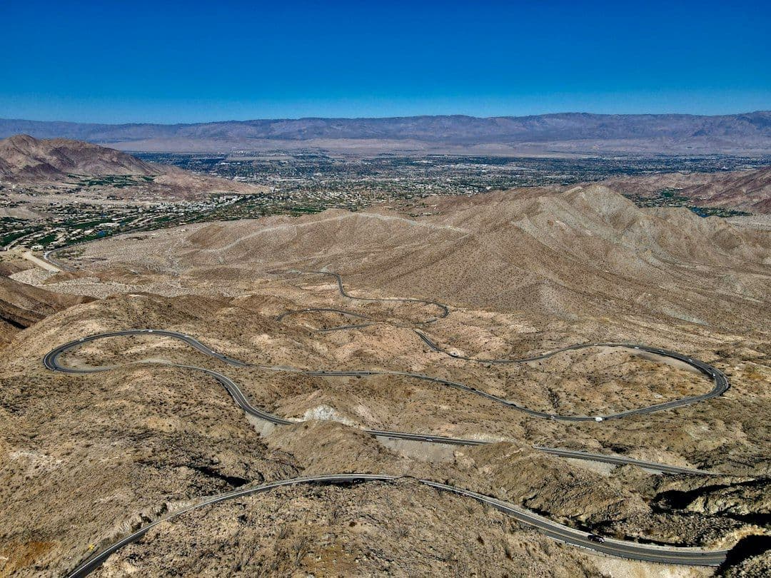 an aerial view of a winding road in the desert