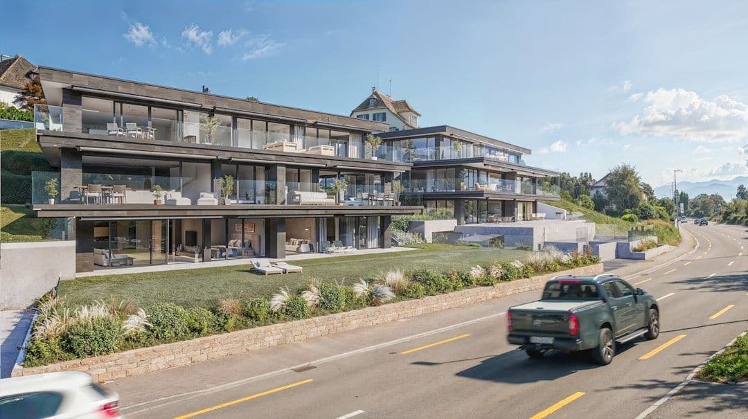 Modern residential building with balconies alongside a busy road